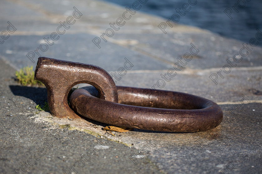6H1C2041 
 Mooring ring 
 Keywords: pier, ship, ring, boat, dock, harbor, background, old, water, outdoor, day, metal, stone, rust, wharf, moor, mooring, blue, abstract, light, travel, vintage, nobody