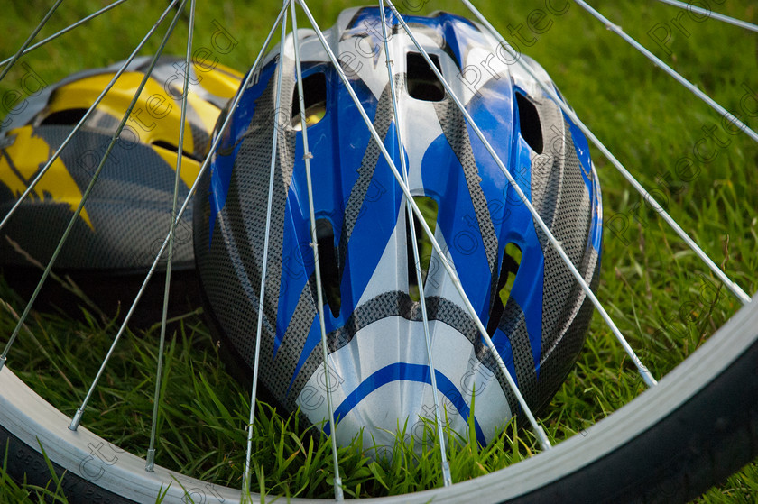 Cycling-001 
 Bicycle helmets and wheel 
 Keywords: bike, bicycle, helmet, grass, close up, wheel, spring, lawn