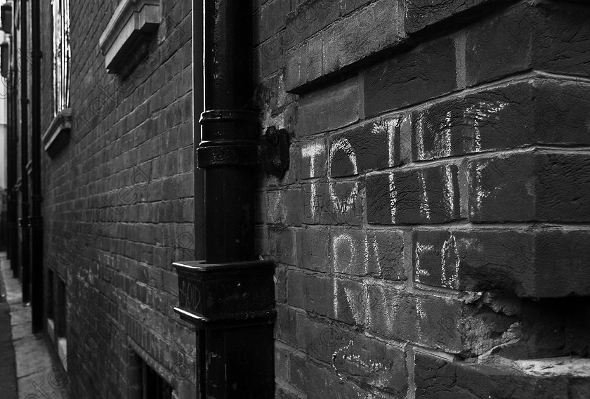 UK Cambridge DSC 0292 
 Writing in chalk on the wall To The River 
 Keywords: brick, building, Cambridge, chalk, city, graffiti, monochrome, outdoors, outside, sign, town, United Kingdom, urban, writing, wall,