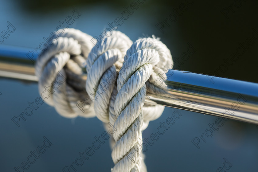 6H1C1597 
 Rope on boat 
 Keywords: rope, boating, boat, detail, yachting, yacht, nautical, nautic, closeup, cruise, steel, cord, deck, travel, power, winch, ship, equipment, recreation, transport, sailboat, maritime, marine, moored, sea, vessel, metal, ocean, twisted, white, regatta, tying, close-up, rigging, object, attached, blue, sail, water, knot
